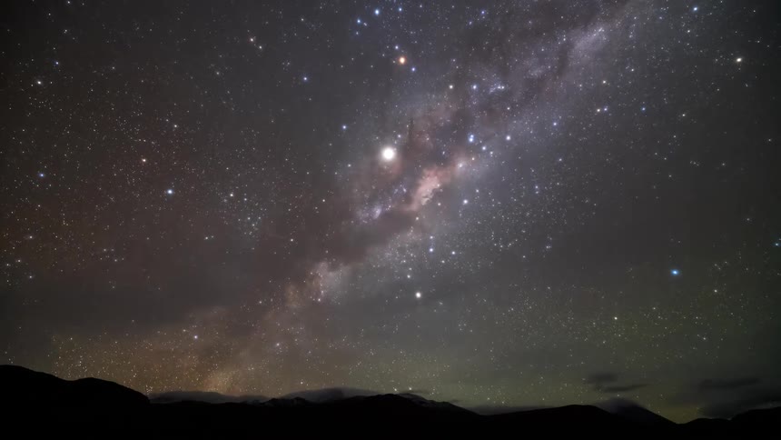 A view of a night sky with many stars and a galaxy and it is dawning and the sun appears shining