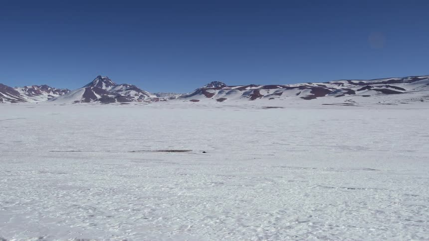 A rocky mountain range with snow in the flat landscape during winter