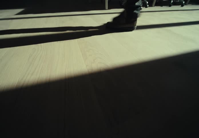 A person walks across the wood floor