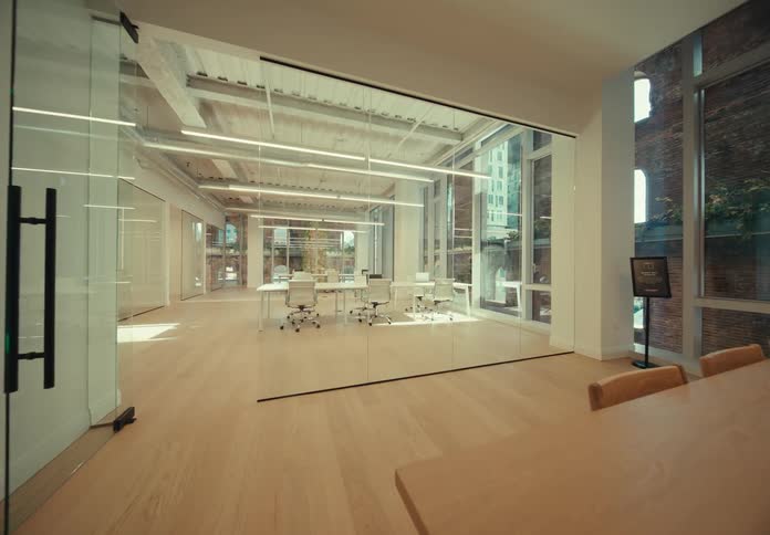 A view of an office with a lot of glass rooms