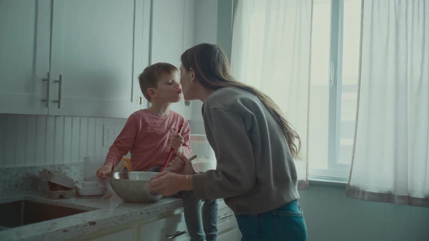 A mother and her son making some treats in a room