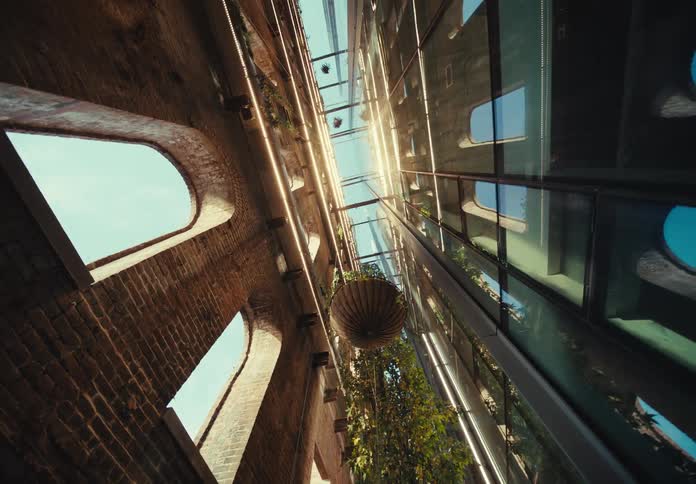 Hanging plants are located between two walls of a building