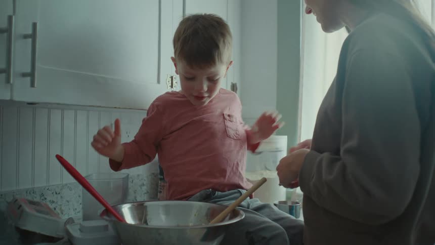 Portrait of a boy helping his mother in the kitchen
