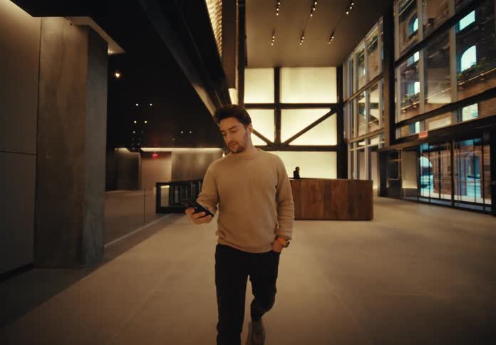 Man using his cell phone while leaving the lobby of a building