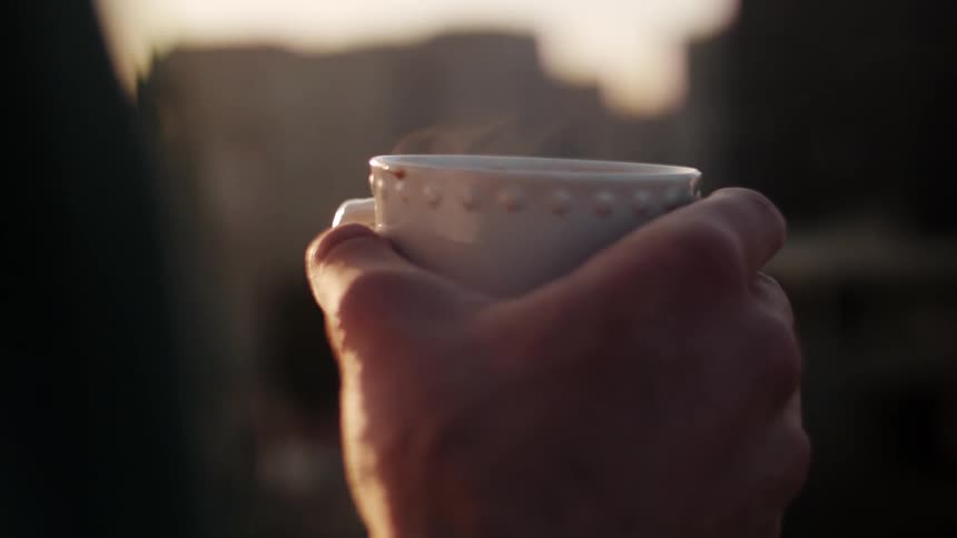 Man holds a white cup