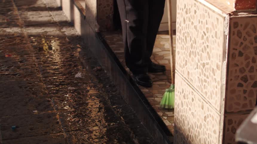 An employee sweeps the water from the building hall