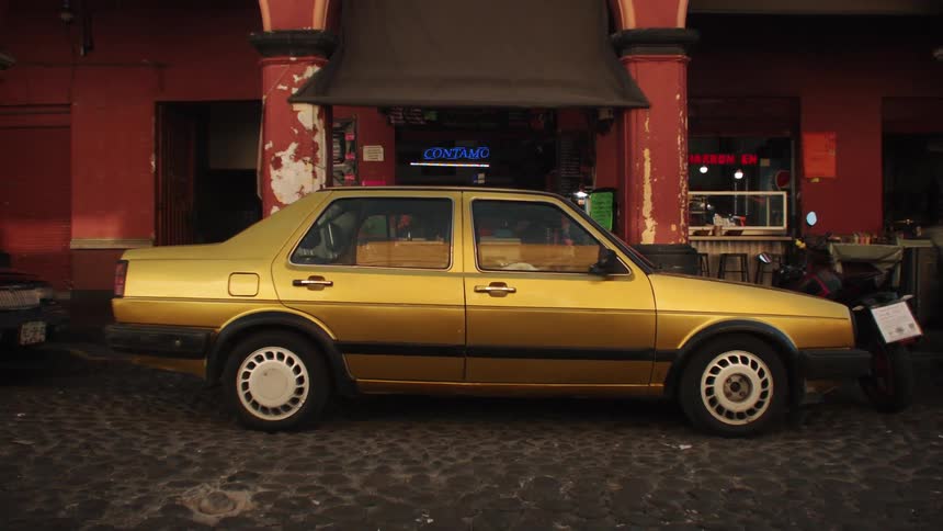 Vintage yellow sedan in front of a restaurant