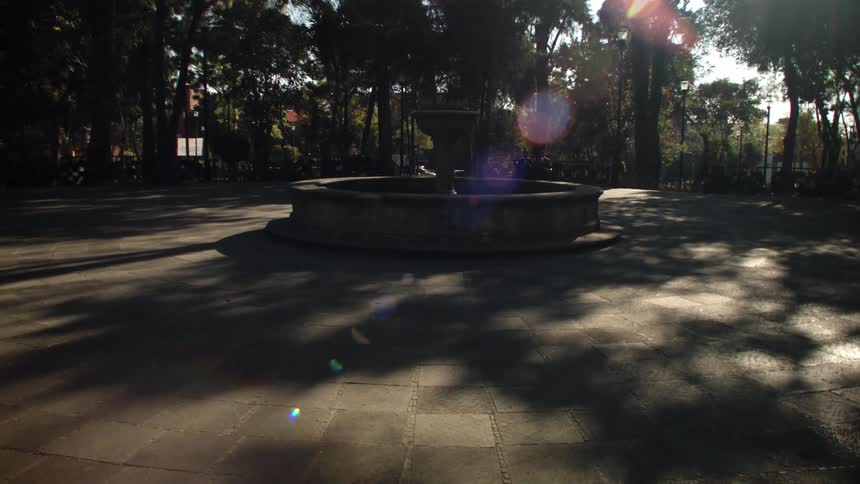 A water fountain in the middle of the park during sunny day