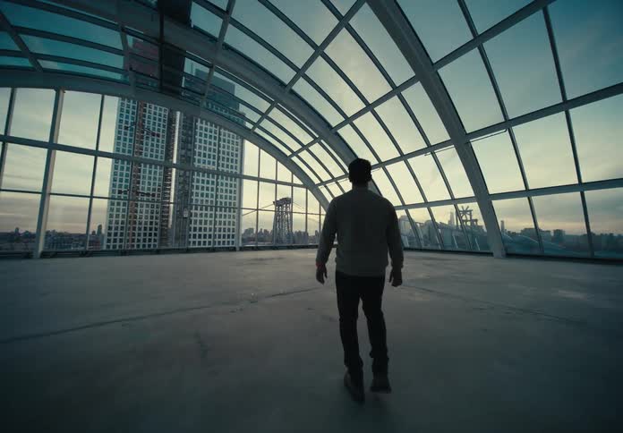 Man wearing a shirt and pants walks through a corridor to the closed terrace