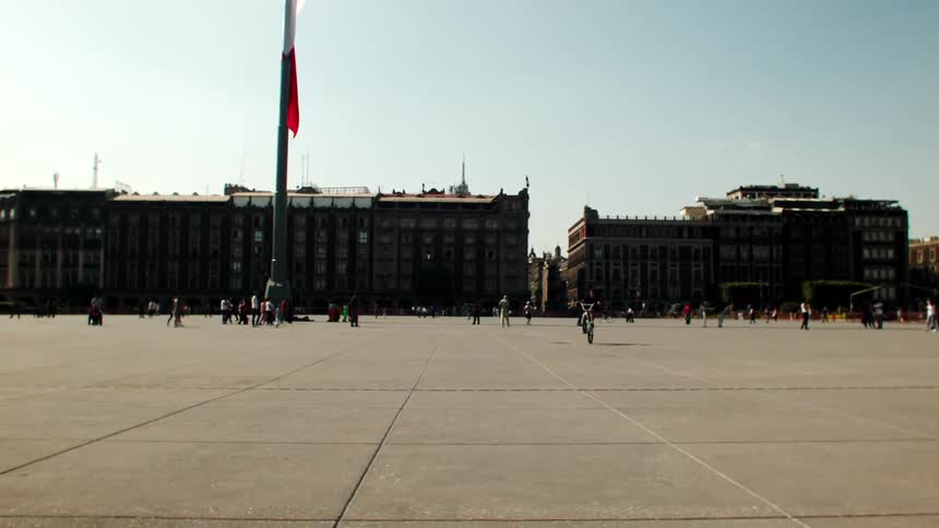 View of a square with people walking and biking in the city on a morning