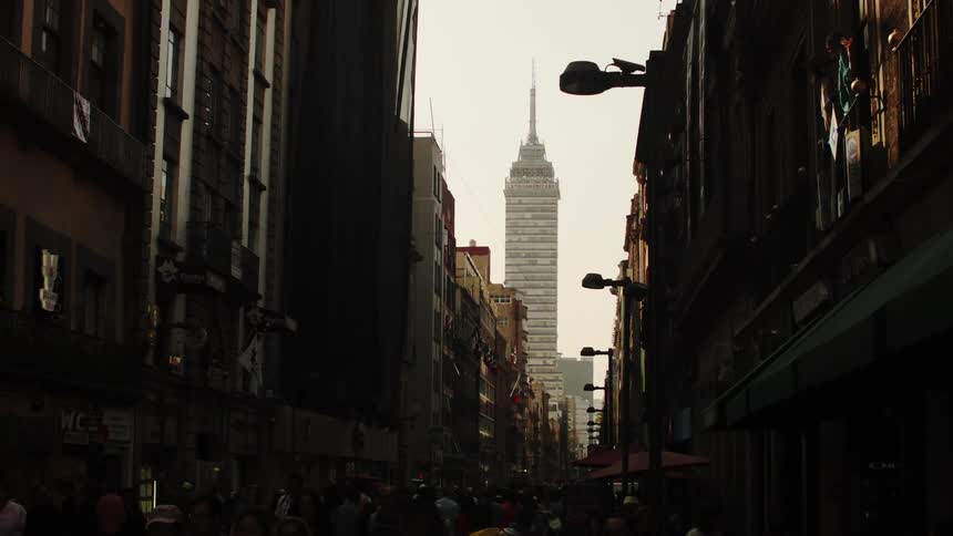 Panorama of a crowded street with pedestrians walking in the midst of a city