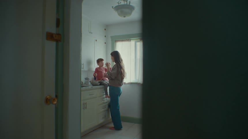 A boy feeds his mother with the cookies they are making together
