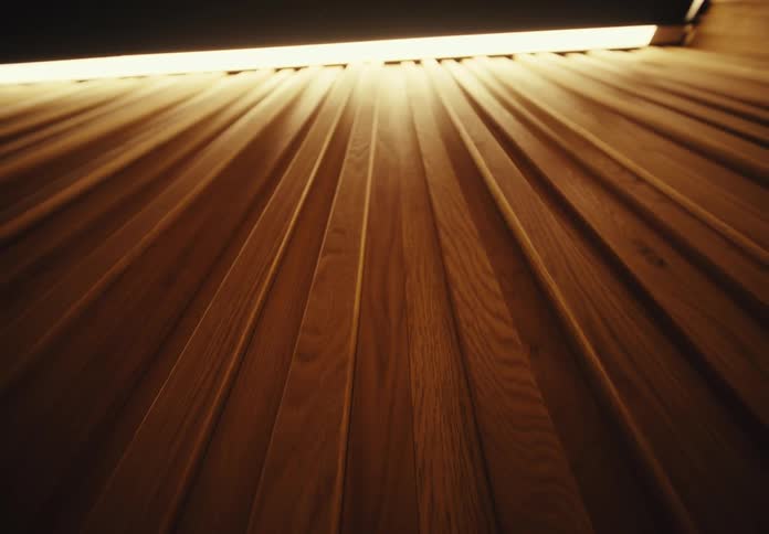 Surface of a wooden wall indoors and a light fixture on the ceiling next to it
