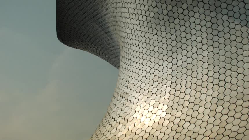 Tall metallic roof with geometric shapes reflects sunlight