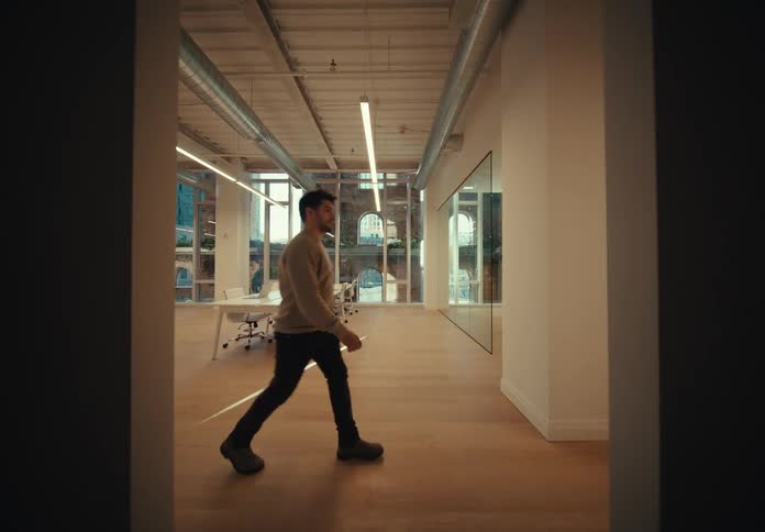 Internal architecture of a man passing through a corridor of a room with a white table in a building