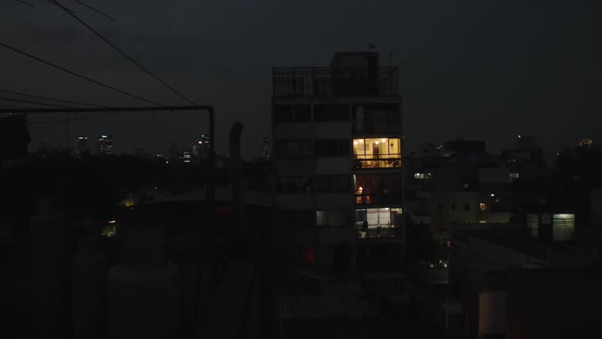A window of a small building has the light on one night