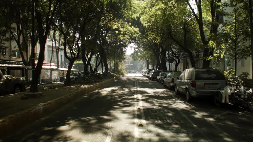 Cars line road leading past apartment buildings to intersection