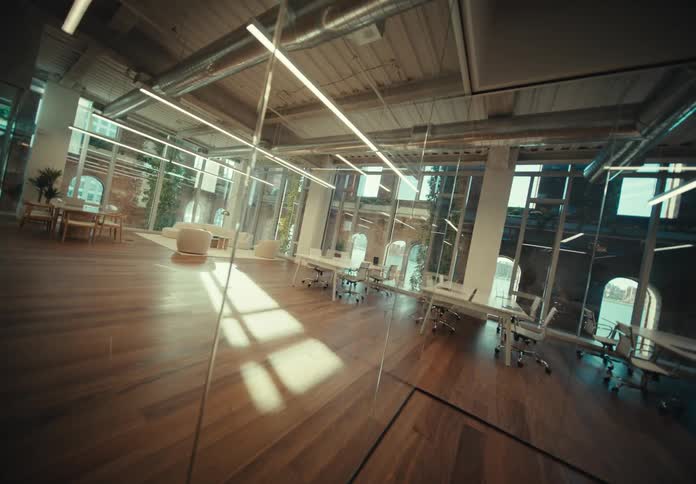 Spacious office with white desks chairs and mirrors