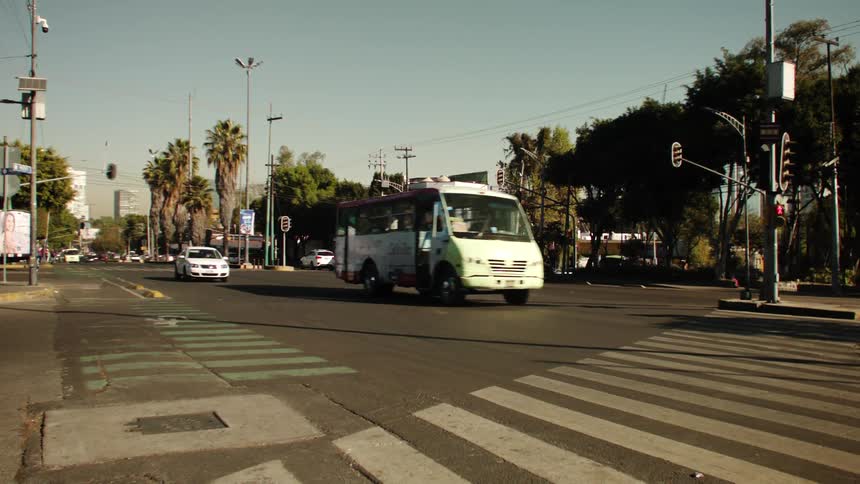 Panorama of a road in the midst of a city with private and public vehicles and pedestrians