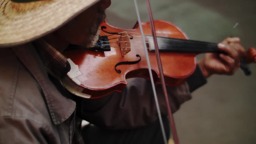 Man wearing a sunhat plays violin