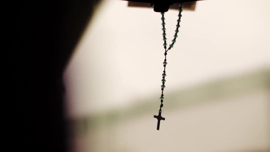 A crucifix hanging from a car mirror