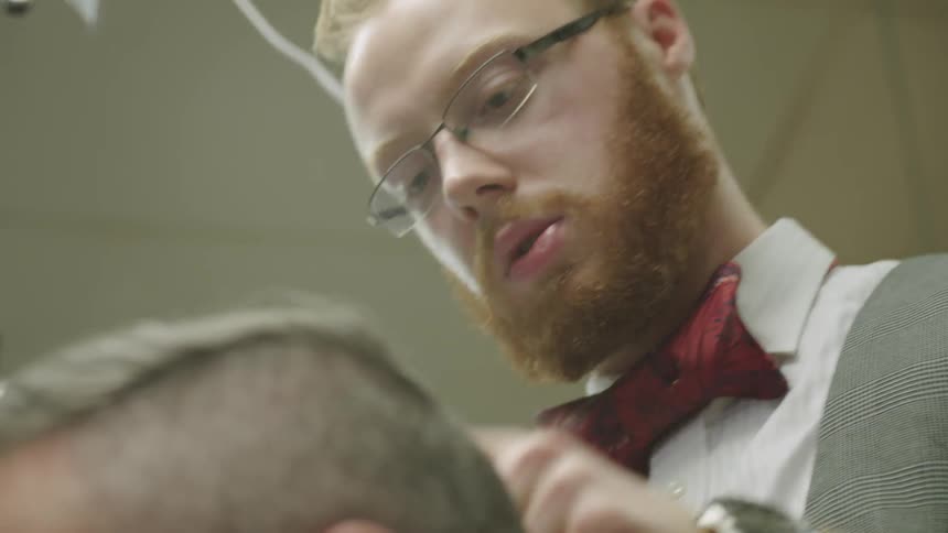 A barber is cutting a man's hair