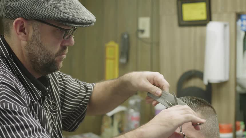 A barber trims a man’s hair