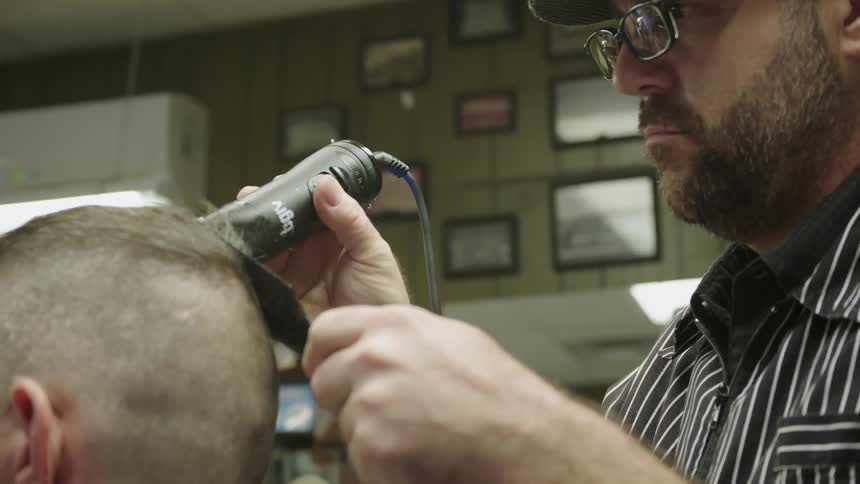 A barber is cutting a man's hair