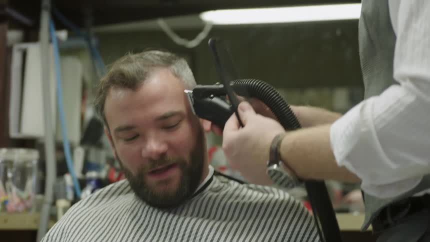 Man talking to a barber as he is getting his hair cut