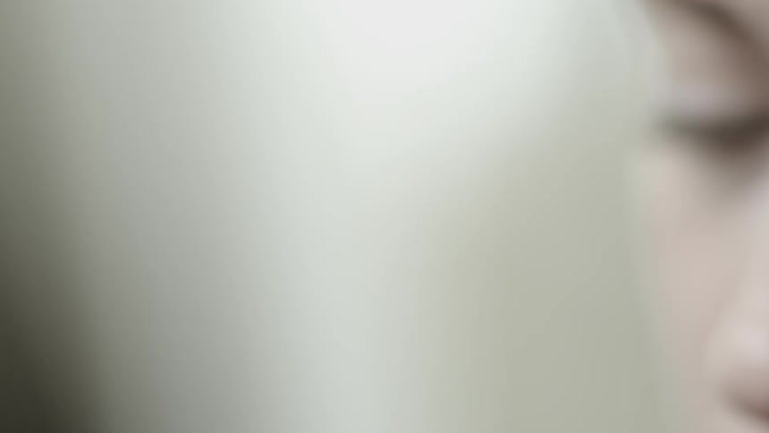 A woman dabs makeup onto her face