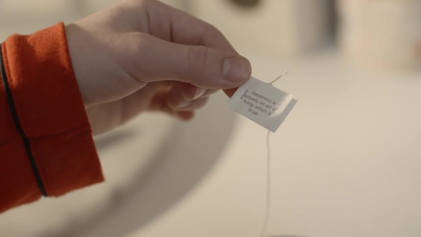 A woman holds a small piece of paper with text