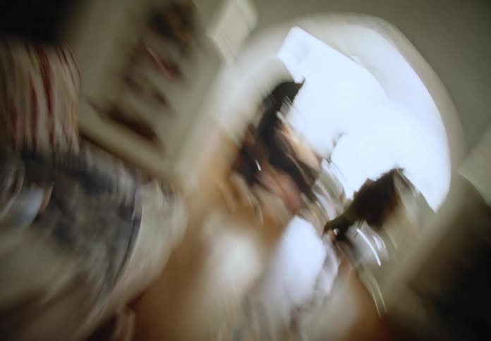 Girl and man move through living room in timelapse
