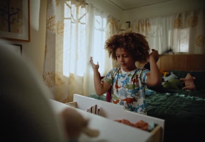 Little boy taking clothes out of the closet and throwing them back inside the room