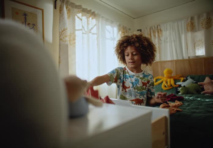 Child throws clothes from drawers onto the bed