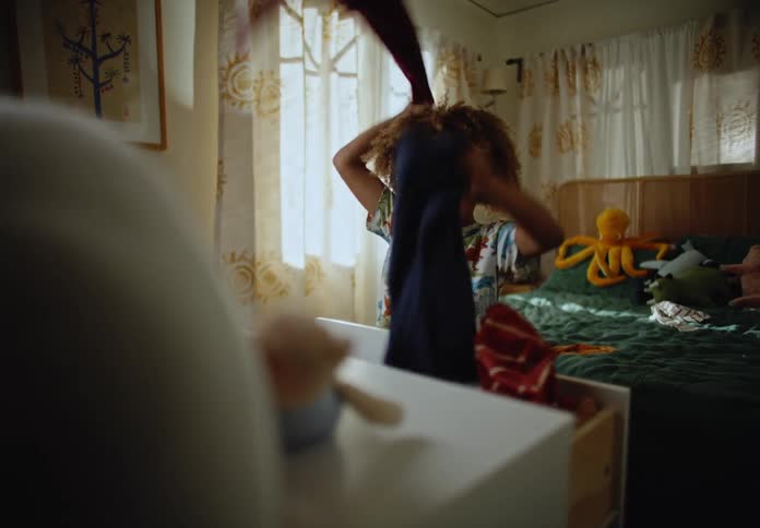 Boy taking clothes out of the closet and throwing them back on the bed