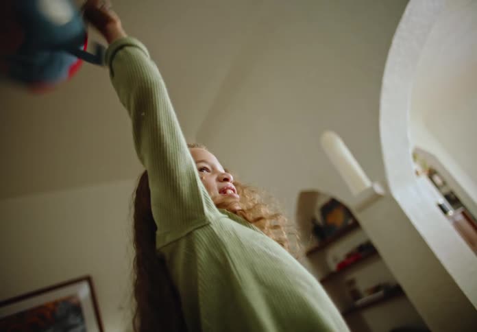 A little girl twirling a stuffed animal in her hands