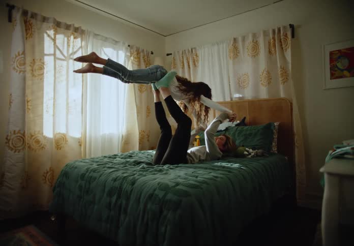 Mother and daughter playing with airplanes on the bedroom bed
