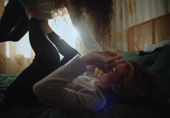 A mother and daughter play in bed