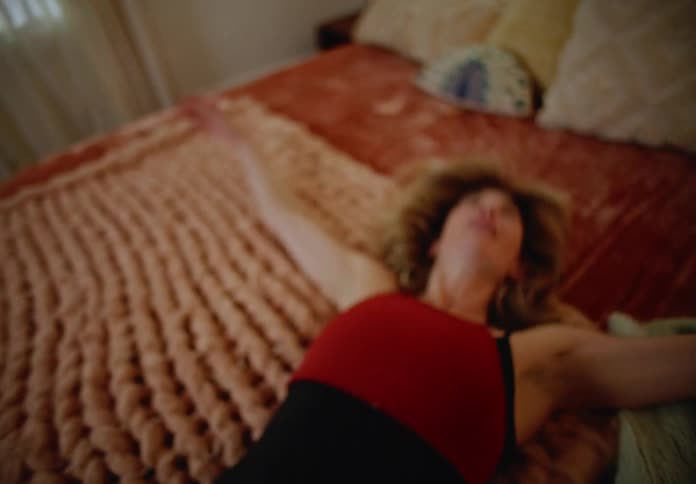 A woman lays down on her bed