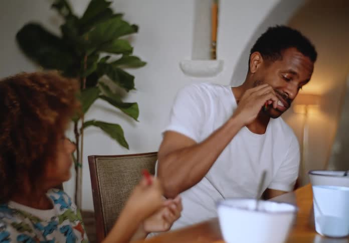 Portrait of father and his little son eating sweets at a table