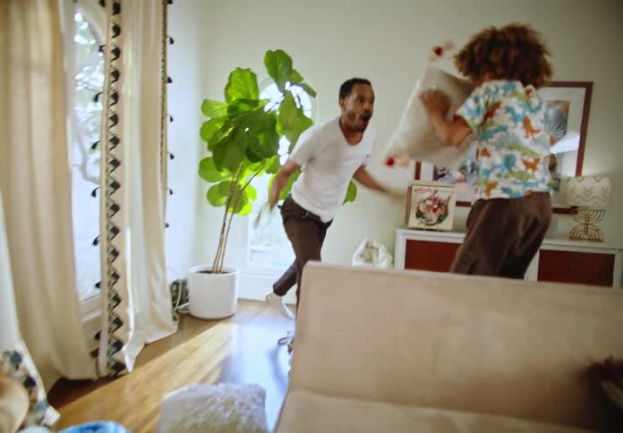 A father plays with his kids in the living room