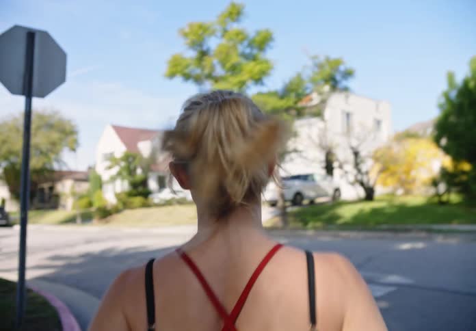 A woman running through the streets of a neighborhood during the day