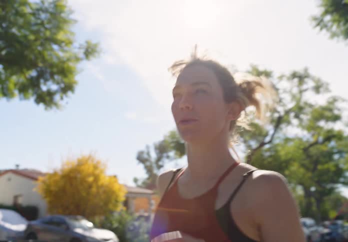 A woman running outdoors on a sunny day
