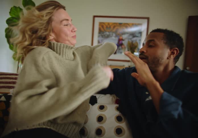 Couple sitting on the sofa in the living room talking and holding hands with each other