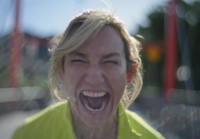 Portrait of a blonde woman outdoors screaming fiercely