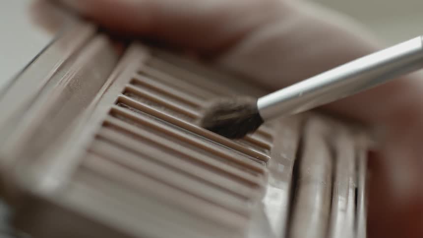 A brush is tapped on an eyeshadow palette
