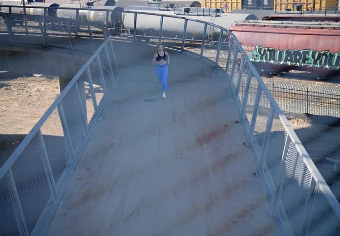 A clip of a lady on black to and blue pants jugging at a factory