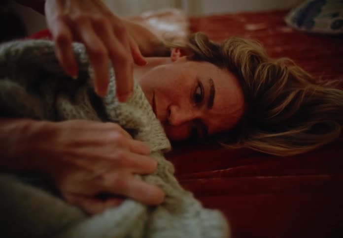 A woman rubs a sweater on her face