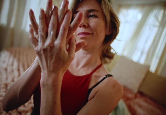 A woman is putting hand cream on her hands