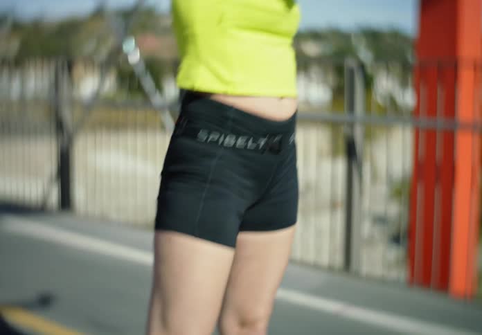 A young woman performs stretches on a bridge